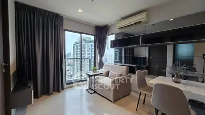 Modern living room with city view, featuring sleek furniture and large windows for natural light.