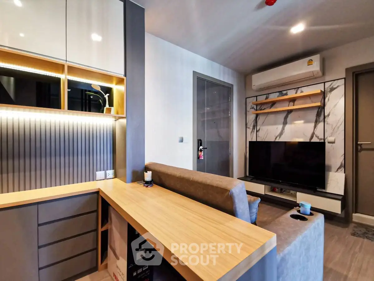 Modern living room with sleek furniture and built-in storage, featuring a stylish TV setup.