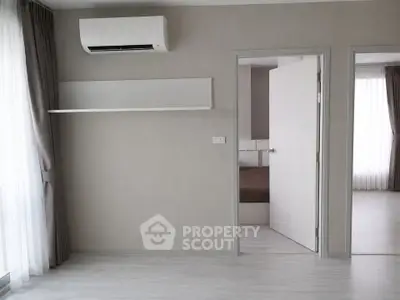 Modern minimalist interior with air conditioning and open door to bedroom, featuring sleek design and natural light.