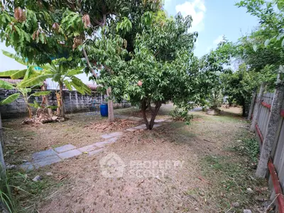 Spacious garden with lush trees and a serene pathway, perfect for outdoor relaxation and nature lovers.