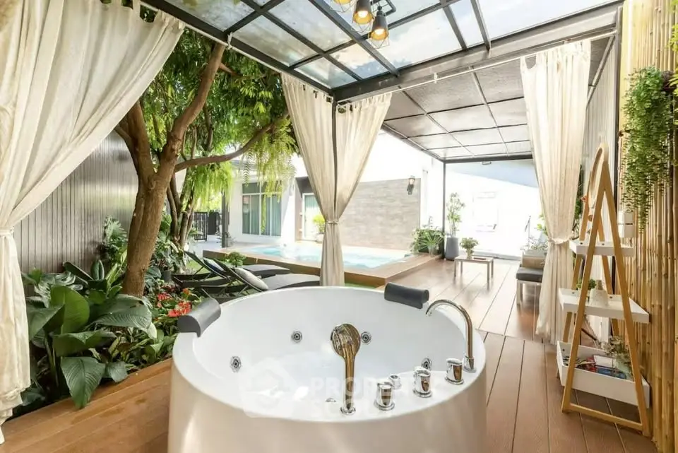 Luxurious outdoor spa area with jacuzzi and pool, surrounded by lush greenery and elegant decor.