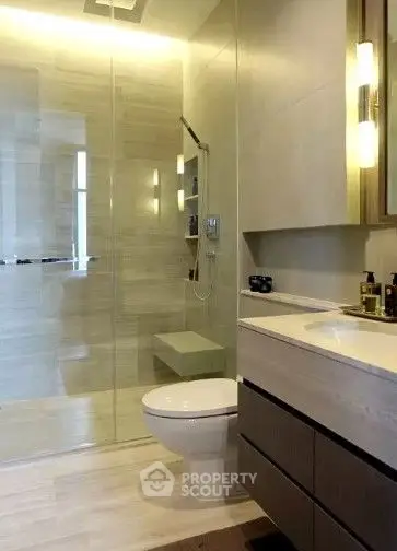 Modern bathroom with glass shower and sleek vanity in luxury home.