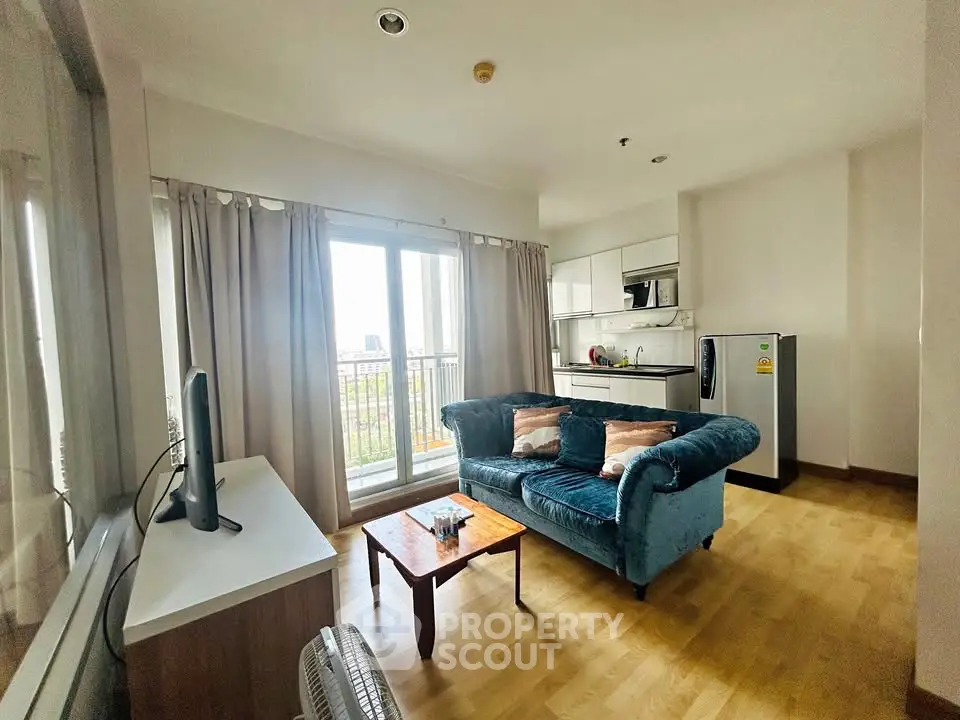 Charming living room with cozy sofa, large window, and modern kitchen in open layout apartment.