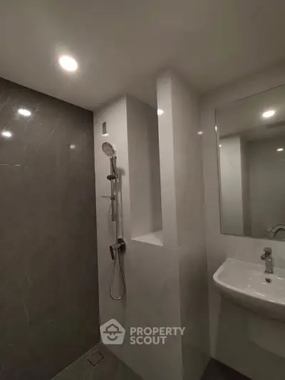 Modern bathroom with sleek shower and elegant sink in a contemporary design.