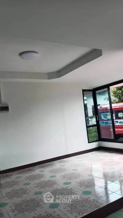 Spacious room with large windows and decorative tiled flooring, ideal for customization.
