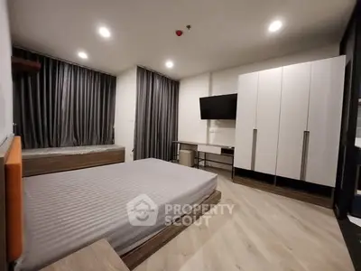 Modern bedroom with sleek design, featuring a large bed, wall-mounted TV, and ample storage space.