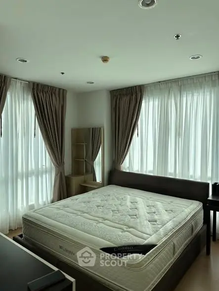 Bright and airy bedroom with large windows and modern furnishings.