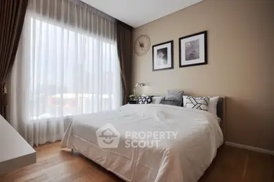 Elegant bedroom with large window and stylish decor in modern apartment.