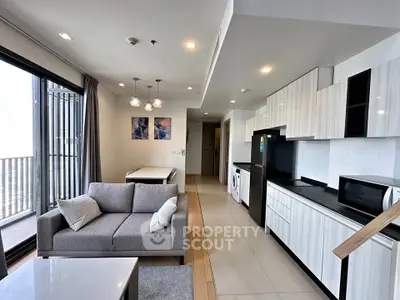 Modern open-plan living room and kitchen with sleek design and natural light.