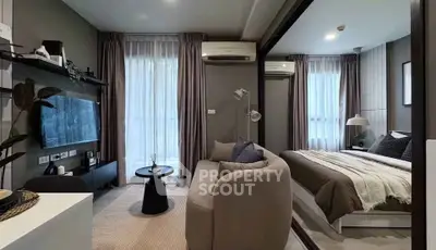 Modern studio apartment with cozy living area and stylish bedroom, featuring large windows and elegant decor.