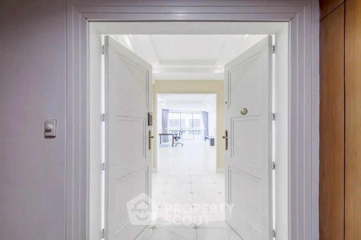 Spacious entrance leading to a bright living area with large windows.