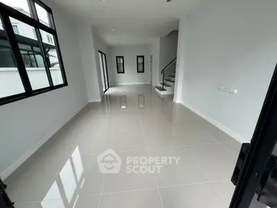 Spacious modern living room with glossy tiled floors and large windows