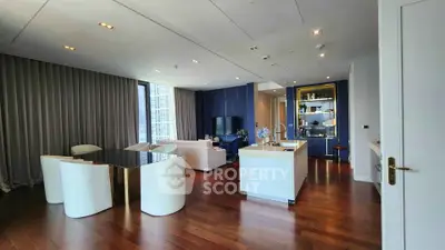 Luxurious modern living room with open kitchen, elegant decor, and stunning city view.