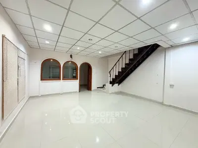 Spacious modern living room with staircase and elegant ceiling design