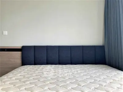 Modern bedroom with stylish headboard and comfortable mattress in a minimalist design.
