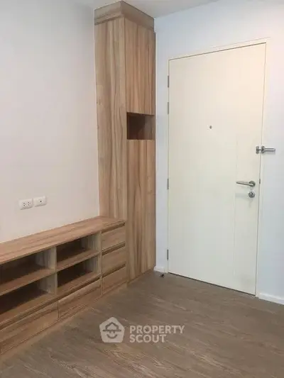 Modern entryway with wooden storage and sleek white door