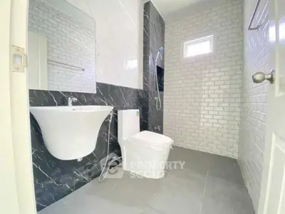 Modern bathroom with sleek black and white tiles and contemporary fixtures.