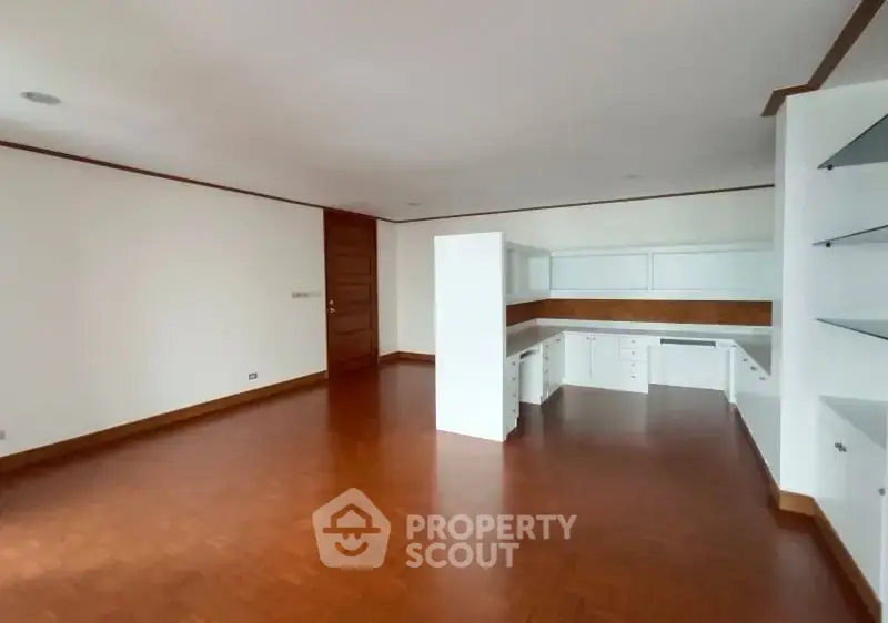 Spacious open-layout kitchen with wooden flooring and modern cabinetry.