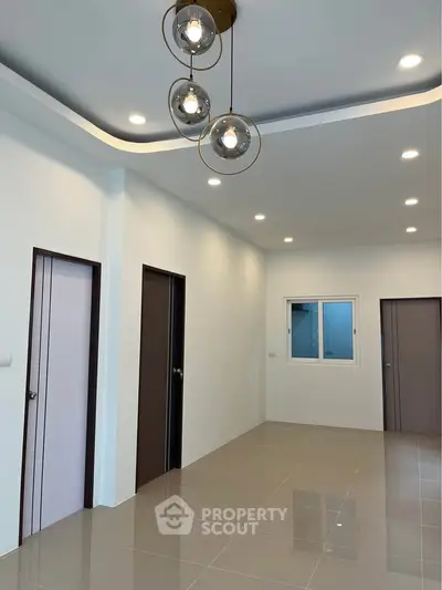 Modern interior with sleek lighting and tiled flooring, showcasing a minimalist design and spacious layout.