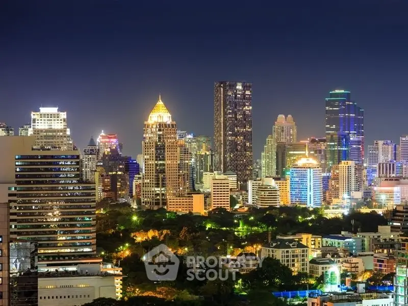 Stunning nighttime cityscape showcasing vibrant skyline with illuminated skyscrapers and lush greenery.