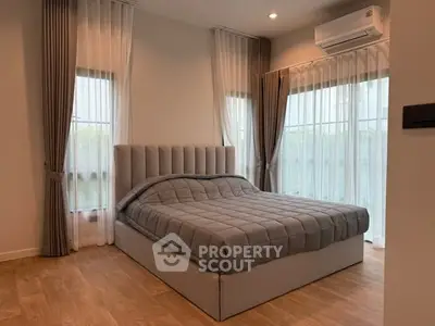 Modern bedroom with elegant decor and large windows for natural light.