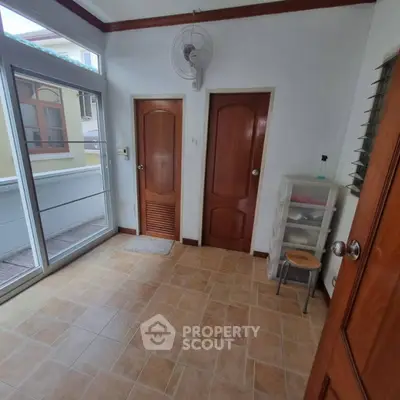 Spacious room with wooden doors and balcony access, ideal for versatile use.