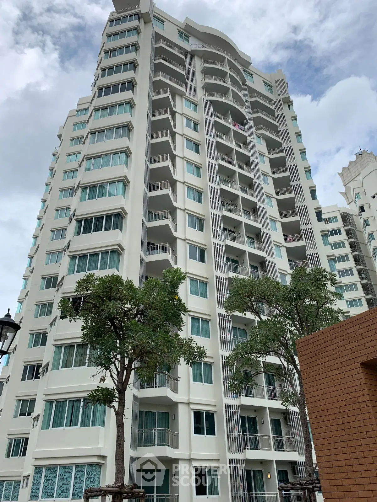 Stunning high-rise residential building with modern architecture and lush greenery.