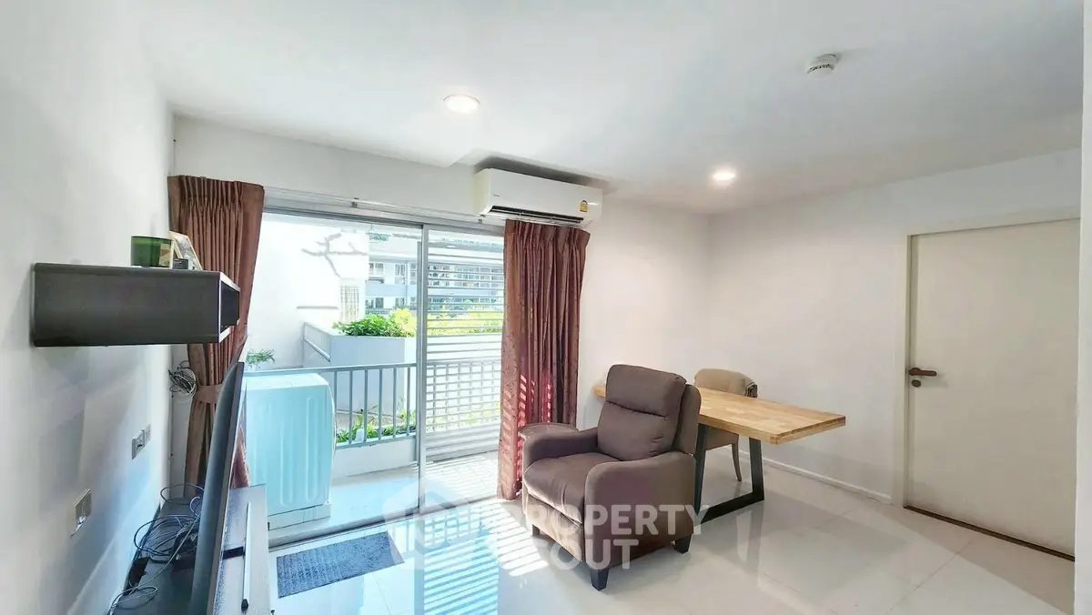 Modern living room with balcony access and cozy seating in a bright apartment.