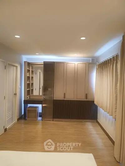 Spacious bedroom with built-in wardrobe and elegant lighting