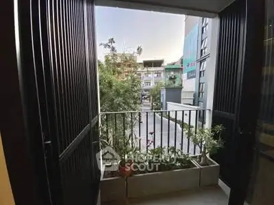 Charming balcony with lush greenery and city view, perfect for relaxation.