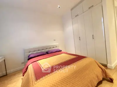 Cozy bedroom with modern wardrobe and stylish bedding in a well-lit space.