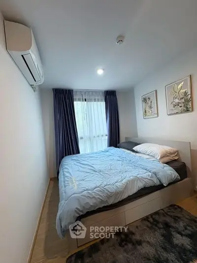 Cozy bedroom with modern decor and natural light, featuring a comfortable bed and stylish artwork.