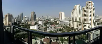 Stunning cityscape view from a high-rise balcony showcasing urban skyline and modern architecture.