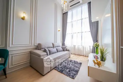 Elegant living room with high ceilings, large windows, and modern decor in a luxury apartment.
