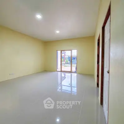 Spacious living room with glossy tiled floors and large window for natural light.