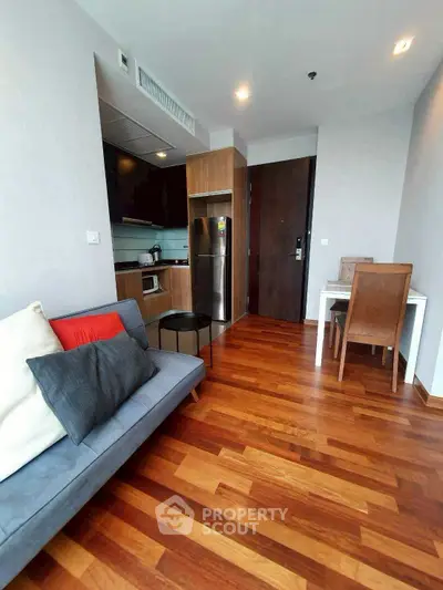 Modern apartment interior with wooden flooring and compact kitchen