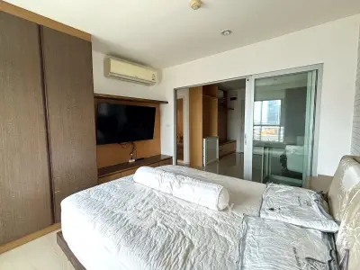 Modern bedroom with sleek design, featuring a large bed, built-in wardrobe, and wall-mounted TV for ultimate comfort.