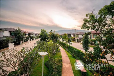 Scenic view of a modern residential neighborhood with lush greenery and mountain backdrop.