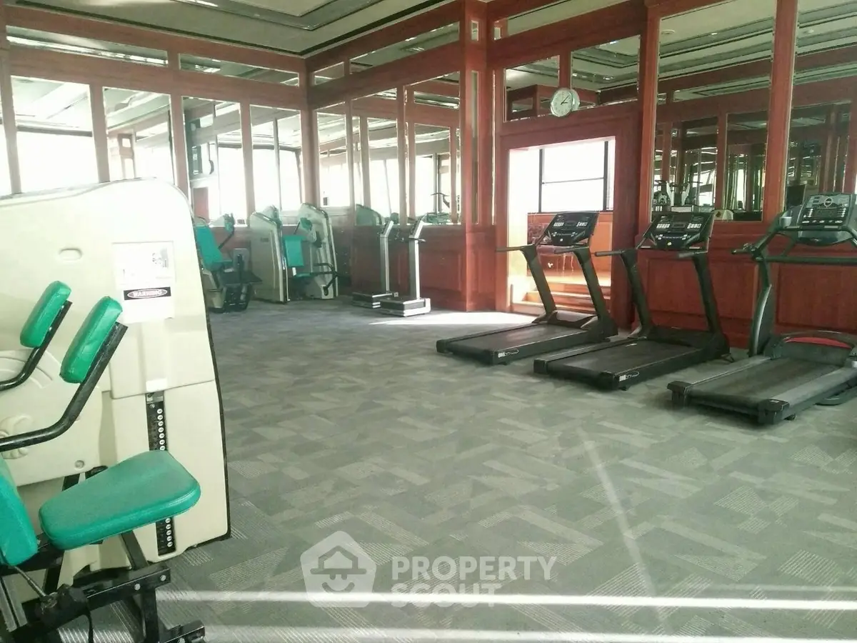 Spacious gym with modern fitness equipment and mirrored walls for an enhanced workout experience.