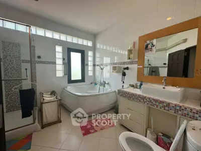 Spacious bathroom with modern fixtures and large corner bathtub, perfect for relaxation.