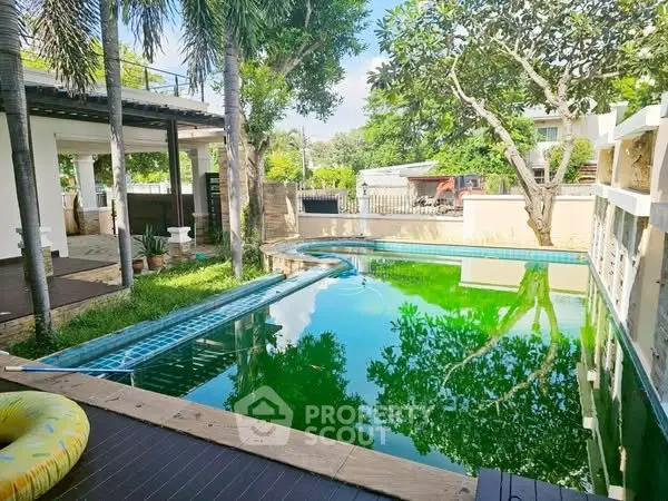 Stunning private pool surrounded by lush greenery in a serene backyard setting.