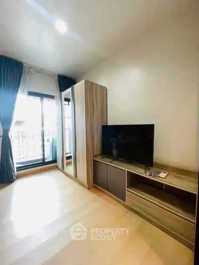 Modern living room with sleek TV stand and large window for natural light.