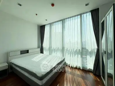 Spacious bedroom with floor-to-ceiling windows and modern decor