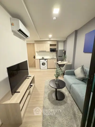 Modern living room with open kitchen, featuring sleek furniture and built-in appliances for a cozy urban lifestyle.