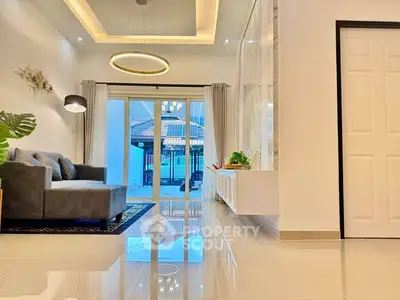 Modern living room with sleek design and large windows offering natural light.