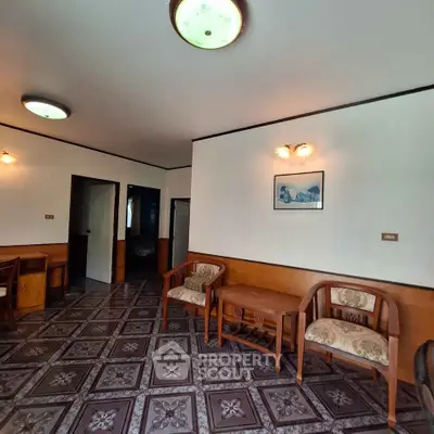 Charming vintage living room with patterned floor tiles and classic wooden furniture.
