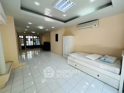Spacious tiled living area with modern lighting and air conditioning