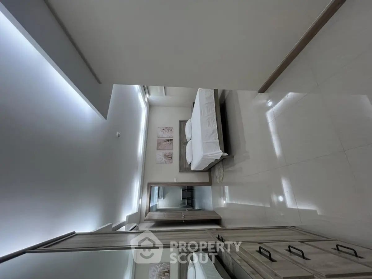 Modern bedroom with sleek design and ample natural light, featuring a comfortable bed and stylish decor.