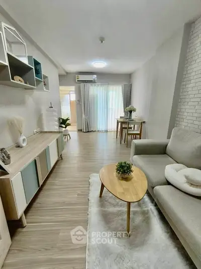 Modern living room with stylish decor and natural light, featuring a cozy sofa and elegant wooden furniture.