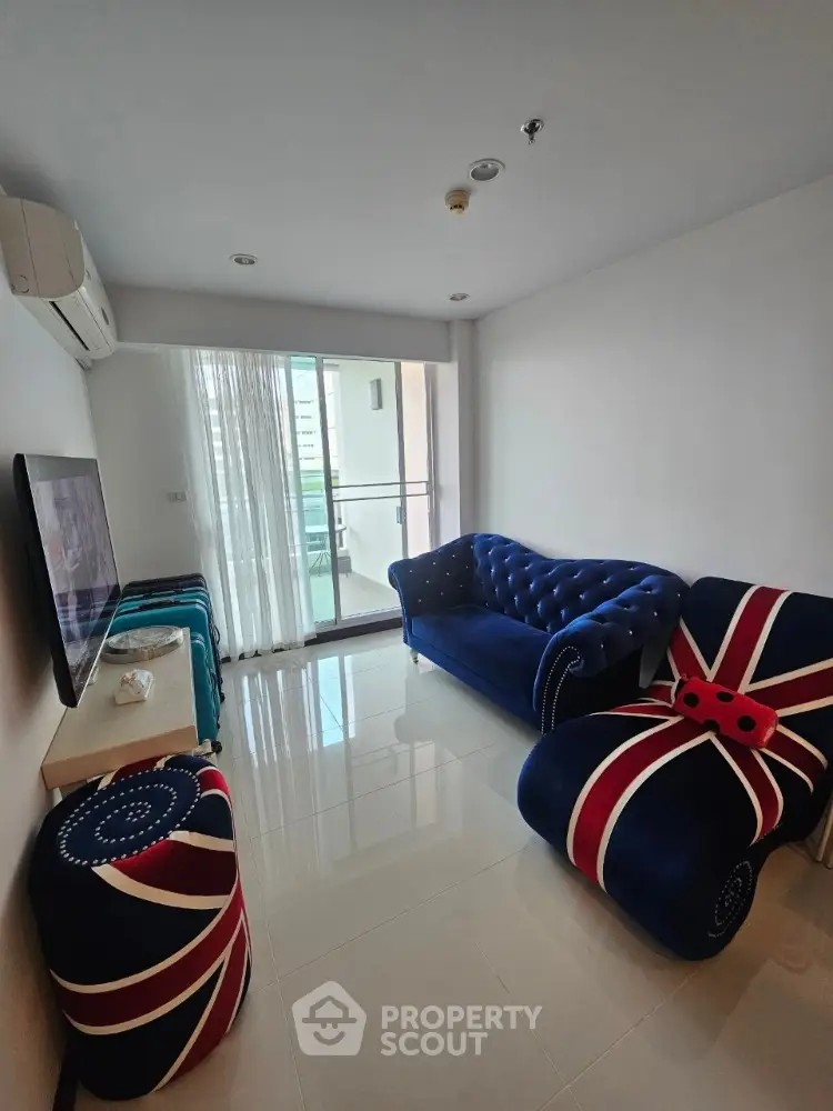 Stylish living room with unique British-themed furniture and balcony access